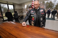 An attendee places a red poppy on U.S. Army Air Forces 2nd Lt. William Scott’s coffin during a ceremony at the Brigadier General William C. Doyle Veterans Memorial Cemetery in Wrightstown, New Jersey, Dec. 9, 2024. Scott, a navigator on a B-24 Liberator bomber, was killed when his aircraft was shot down during Operation Tidal Wave over Ploiești, Romania, Aug. 1, 1943.