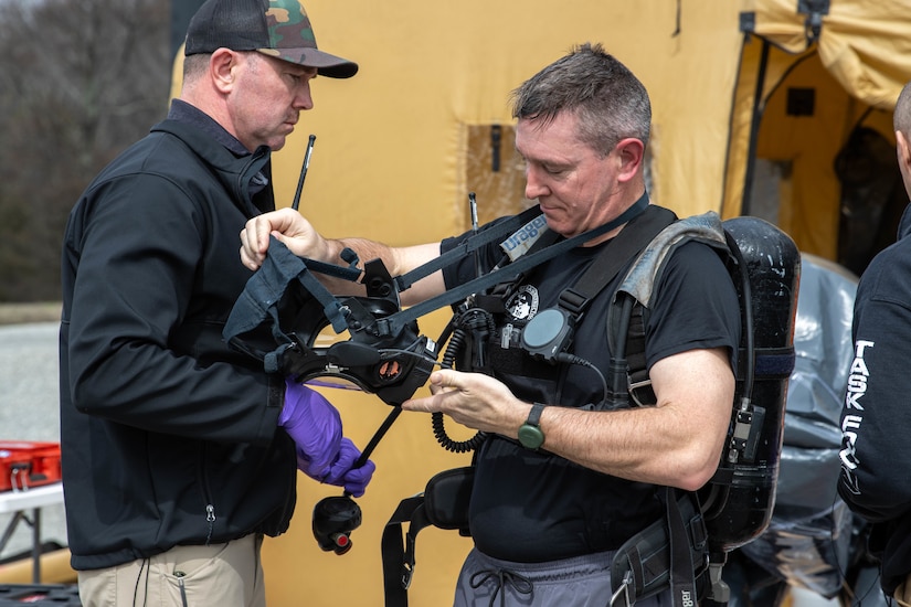 Kentucky Army National Guard Staff Sergeant Zachary Baise of the The Kentucky National Guard's 41st Civil Support Team removes an oxygen mask and tank at a Jim Beam warehouse in Boston, Kentucky, Mar. 7, 2024. The 41st CST were conducting their Training Proficiency Evaluation with ARNORTH there. (Kentucky Army National Guard photo by Capt. Cody Stagner)