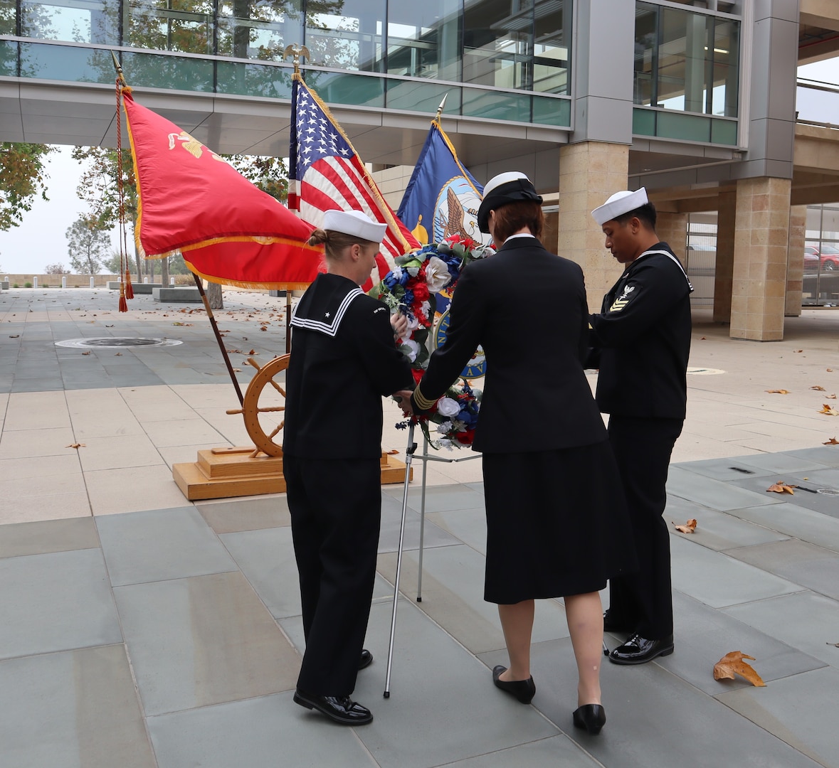 Navy Capt. Jenny Burkett, commander of Navy Medicine Readiness and Training Command Camp Pendleton, with the assistance of 1st Class Petty Officers Brittany Josephson and Christopher Tanner, places a remembrance wreath during the NMRTC CP Pearl Harbor Remembrance Ceremony held in the Naval Hospital Camp Pendleton Medal of Honor Promenade on Friday, Dec. 6, 2024. “As we remember Pearl Harbor, let us commit ourselves to honoring the legacy of those who served and sacrificed. Let their stories inspire us to work for a more peaceful and just world, ensuring their sacrifices were not in vain,” said Burkett during her comments. Planned and executed by the First Class Petty Officer Association, the event honored the 2,403 service members and civilians who died in the attack on the US Naval Base at Pearl Harbor on Dec. 7, 1941.