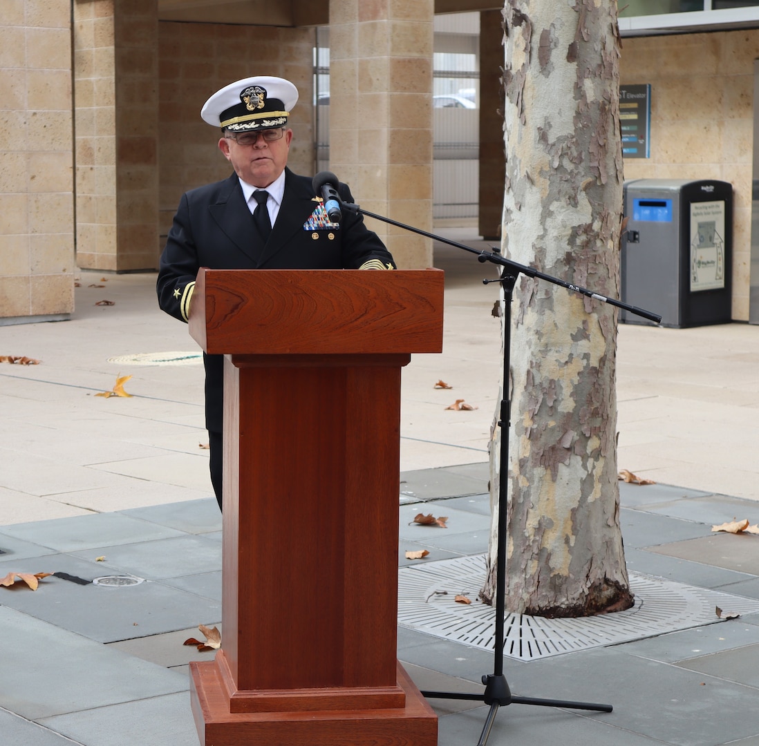 Retired Navy Capt. Donald McMackin speaks to the audience during the Navy Medicine Readiness and Training Command Camp Pendleton Pearl Harbor Remembrance Ceremony held in the Naval Hospital Camp Pendleton Medal of Honor Promenade on Friday, Dec. 6, 2024. McMackin was commissioned in 1980 and served either on active duty or in the reserves as a surface warfare officer until January 2011 and served as the event guest speaker. “When the attack came, off-duty medical personnel and staff streamed back to the facilities. Staff broke out supplies, made more bandages, prepared morphine injections … they set up triage areas, battle dressing stations, organized ambulances and transportation pools,” said McMackin during his comments.  Planned and executed by the First Class Petty Officer Association, the event honored the 2,403 service members and civilians who died in the attack on the US Naval Base at Pearl Harbor on Dec. 7, 1941.