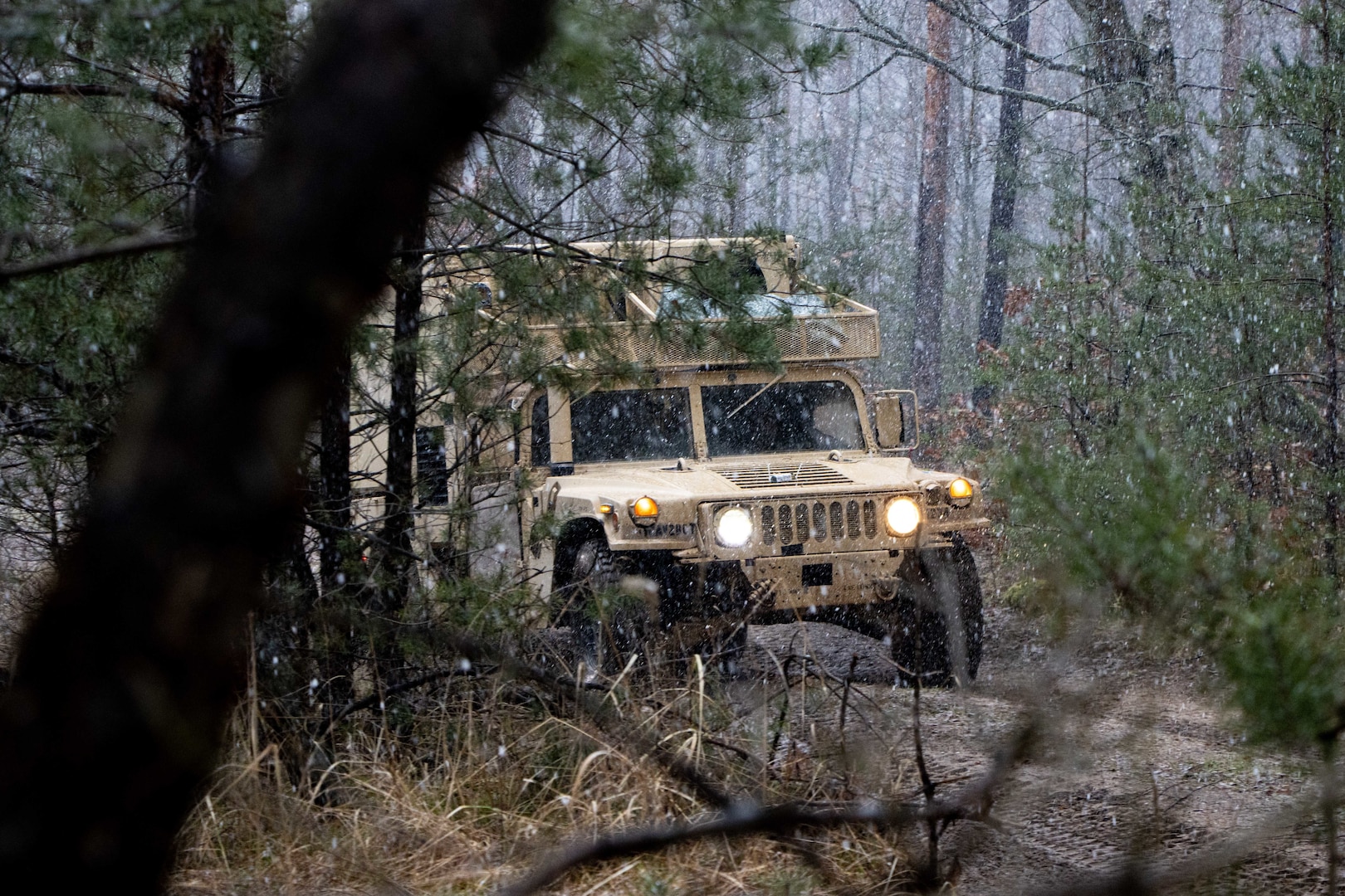 HMMWV drives in the woods as the snow falls