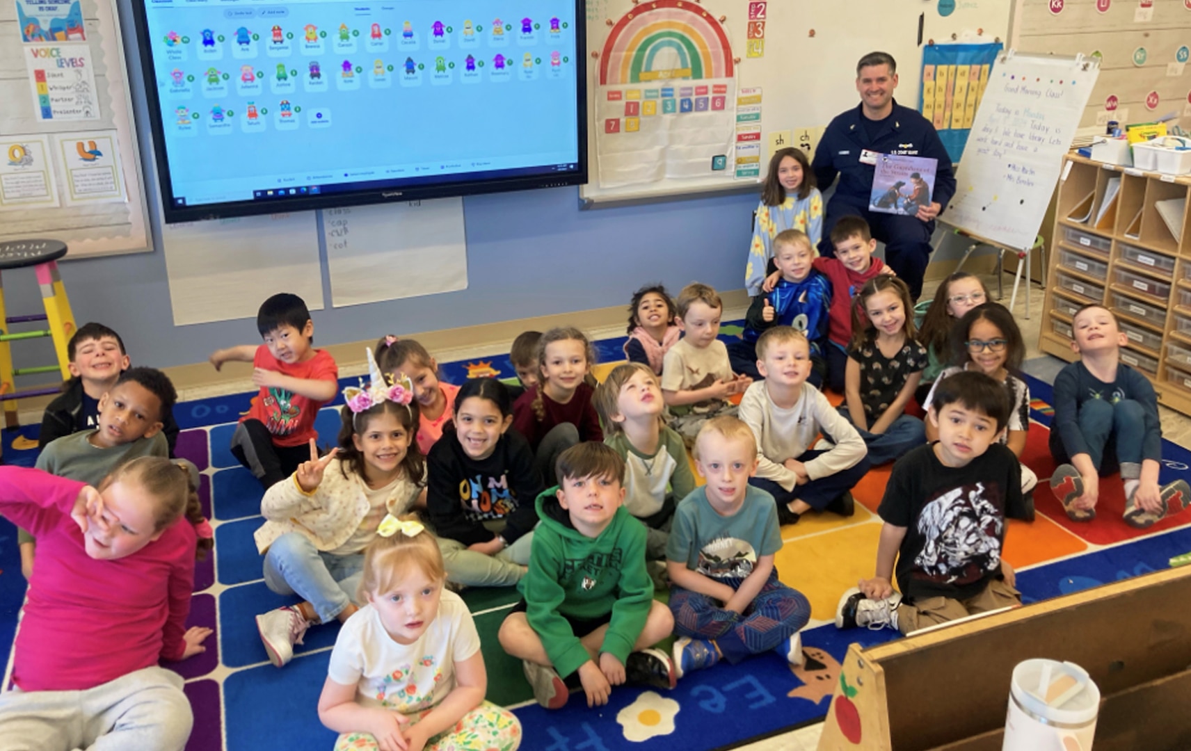 Chief Petty Officer Spencer Hinman reads to kindergarten students at Mitchell Elementary School in Bridgewater, MA. Coast Guard Station Chatham Ma. won Best in Unit Partnership (for up to 100 personnel) Photo by Ms. McKenzie Martin.