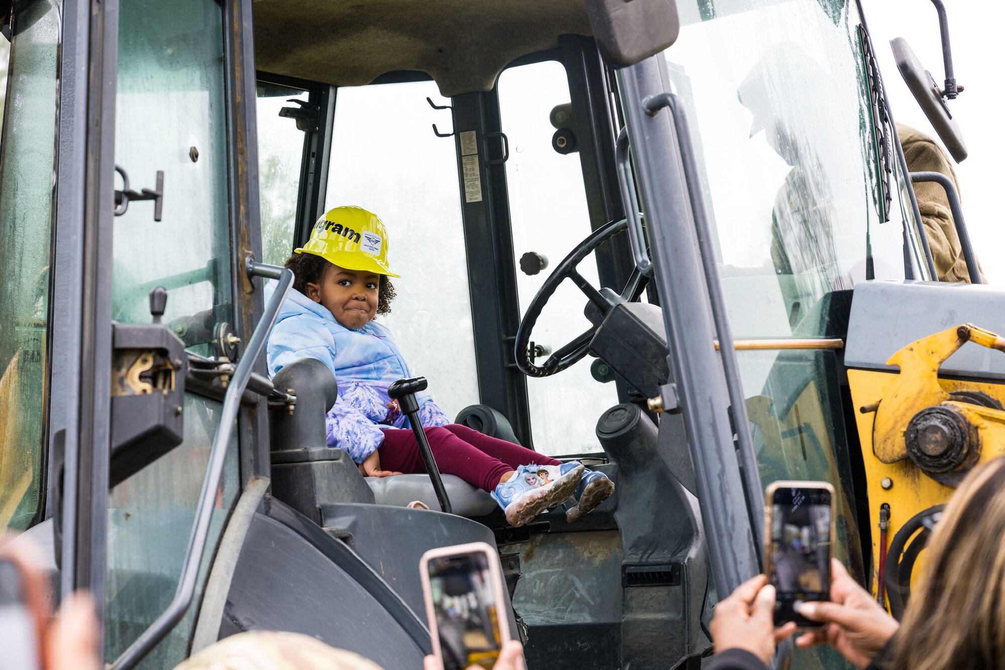 Nylah Mangram sits in a tractor after the child development center groundbreaking ceremony.