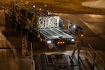Airmen load pallets of ammunition onto a commercial aircraft.