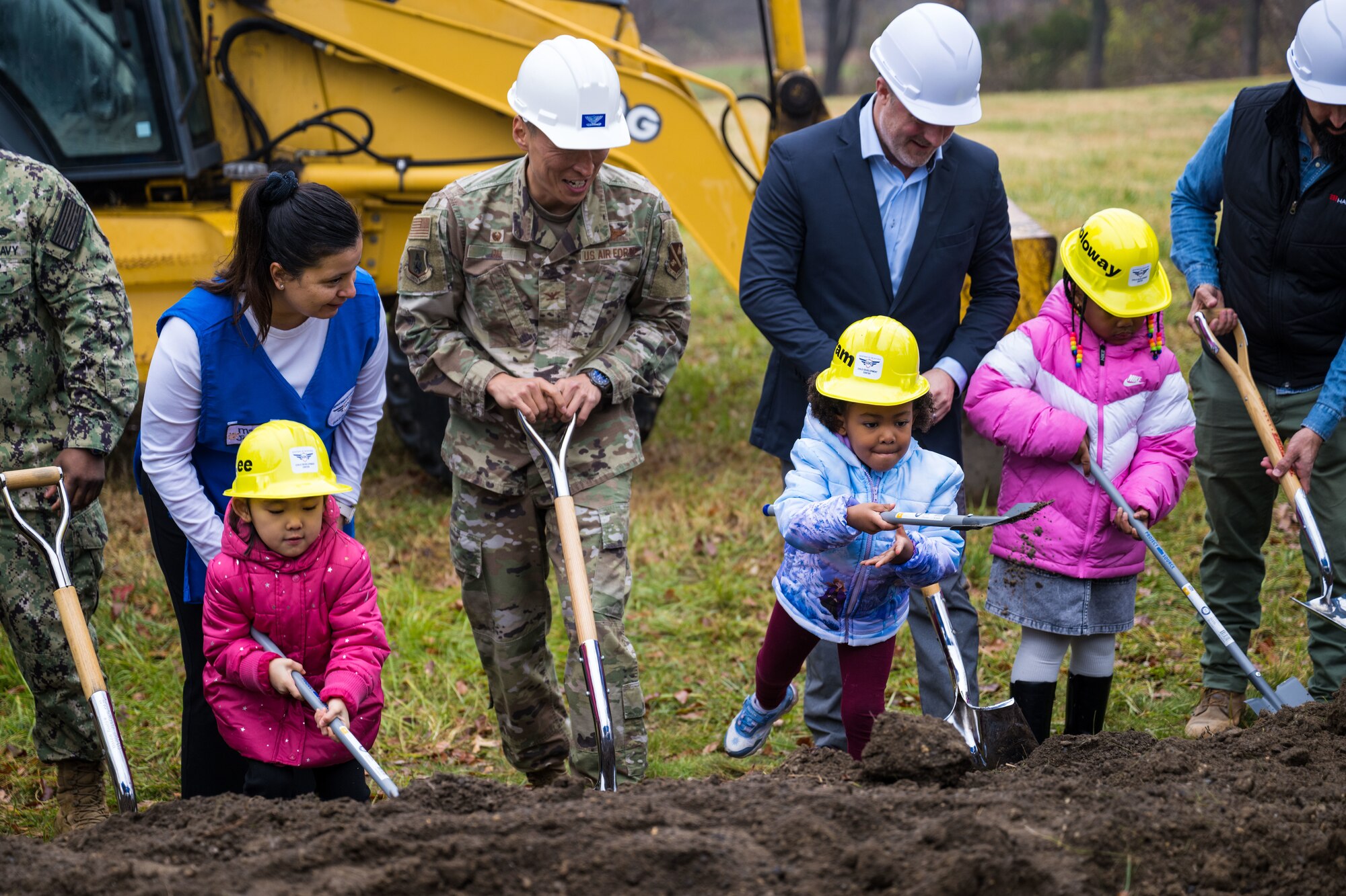 Col Jun S. Oh and children shovel dirt in a groundbreaking ceremony.