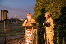 U.S. Air Force Staff Sgt. Steven Lauderdale, 9th Operations Support Squadron airfield operations specialist, and Airman 1st Class Gertrude Namata, 9th Reconnaissance Wing chaplain assistant, sing Christmas carols during the annual Christmas Tree lighting at Beale Air Force Base, California, Dec. 6, 2024.
