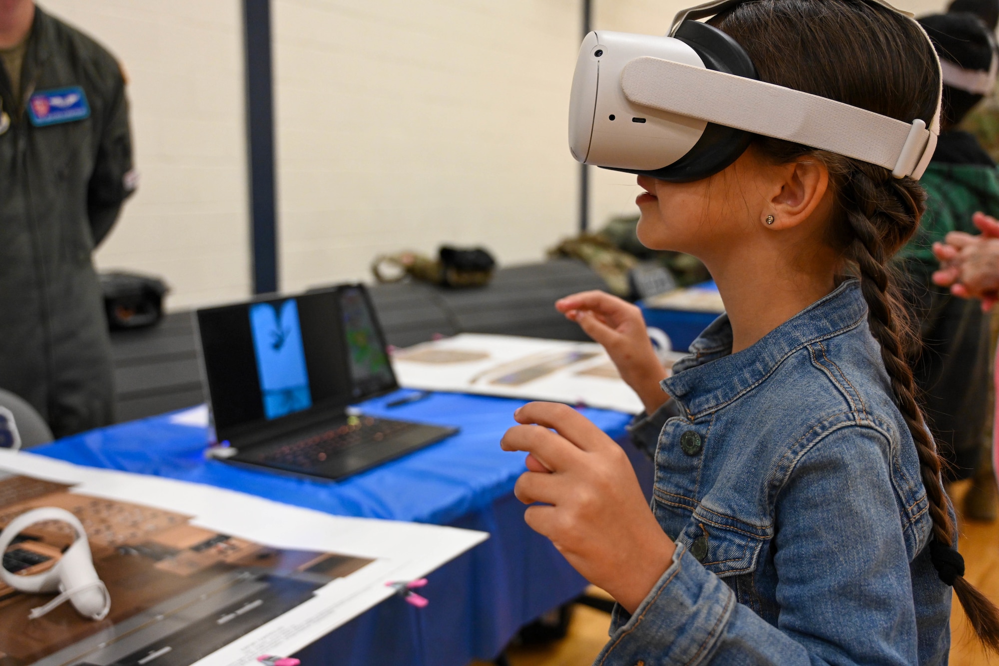 U.S. Air Force Staff Sgt. Jaden Allen, 54th Air Refueling Squadron instructor boom operator, shows air refueling through virtual reality goggles to Zion and Isaiah Taylor, Aviation Inspiration and Mentorship Fair participants, at Altus Junior High School in Altus, Oklahoma, Dec. 7, 2024. The fair allowed children to learn about aviation careers in the Air Force. (U.S. Air Force photo by Senior Airman Miyah Gray)
