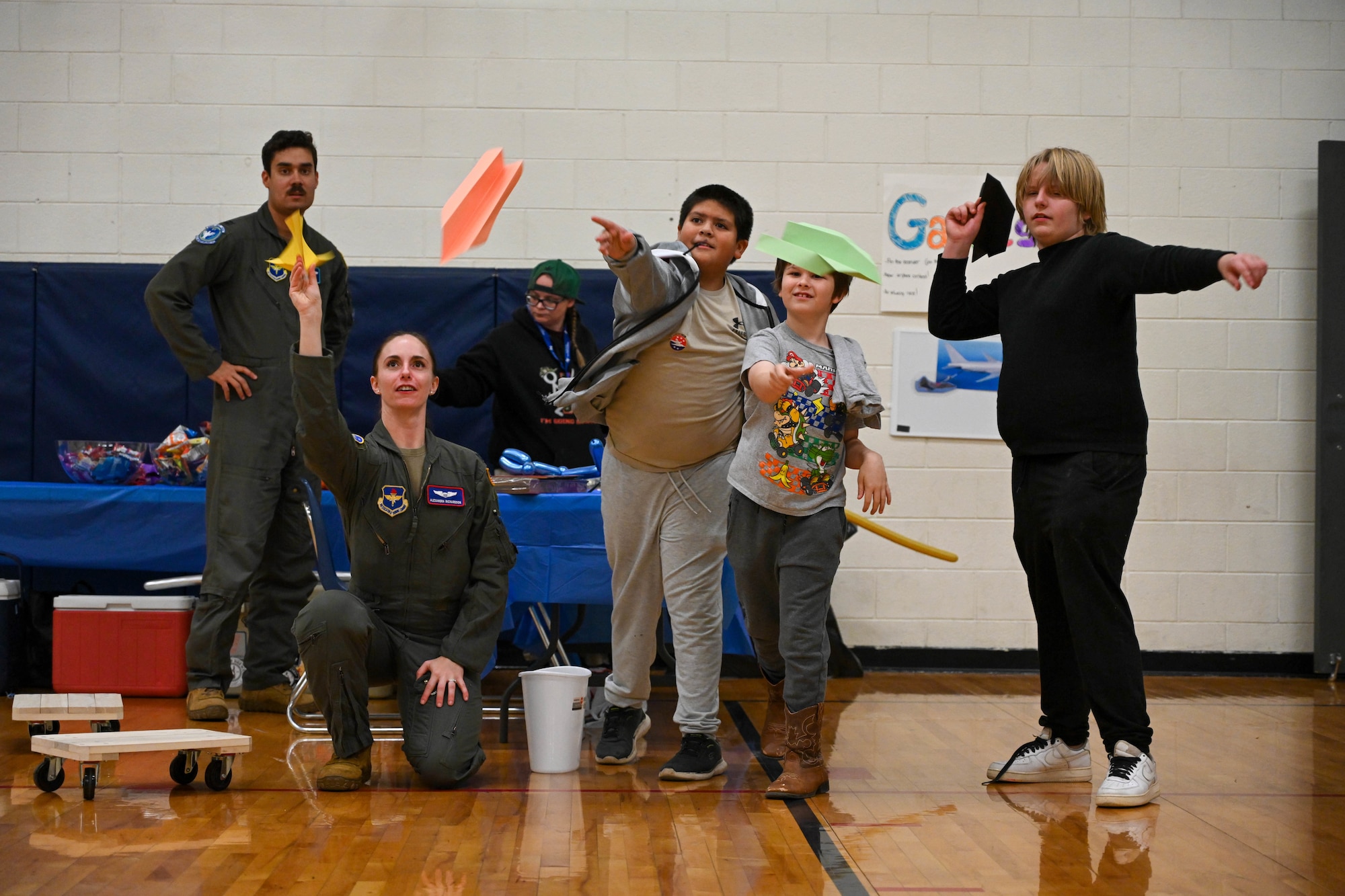 U.S. Air Force Capt. Alexandra Richardson, 54th Air Refueling Squadron resource advisor and KC-135 formal training unit instructor, throws paper airplanes with students during an Aviation Inspiration and Mentorship Fair at Altus Junior High School in Altus, Oklahoma, Dec. 7, 2024. The event was held to inspire the next generation of Airmen. (U.S. Air Force photo by Senior Airman Miyah Gray)