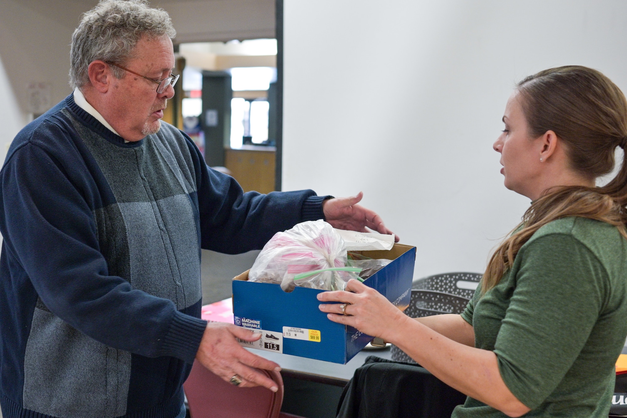 An Alamogordo Chamber of Commerce volunteer delivers a cookie donation to the Holloman Spouses Organization.