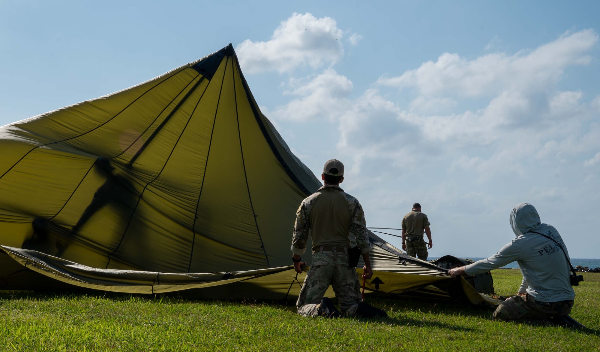 service members putting up a tent.