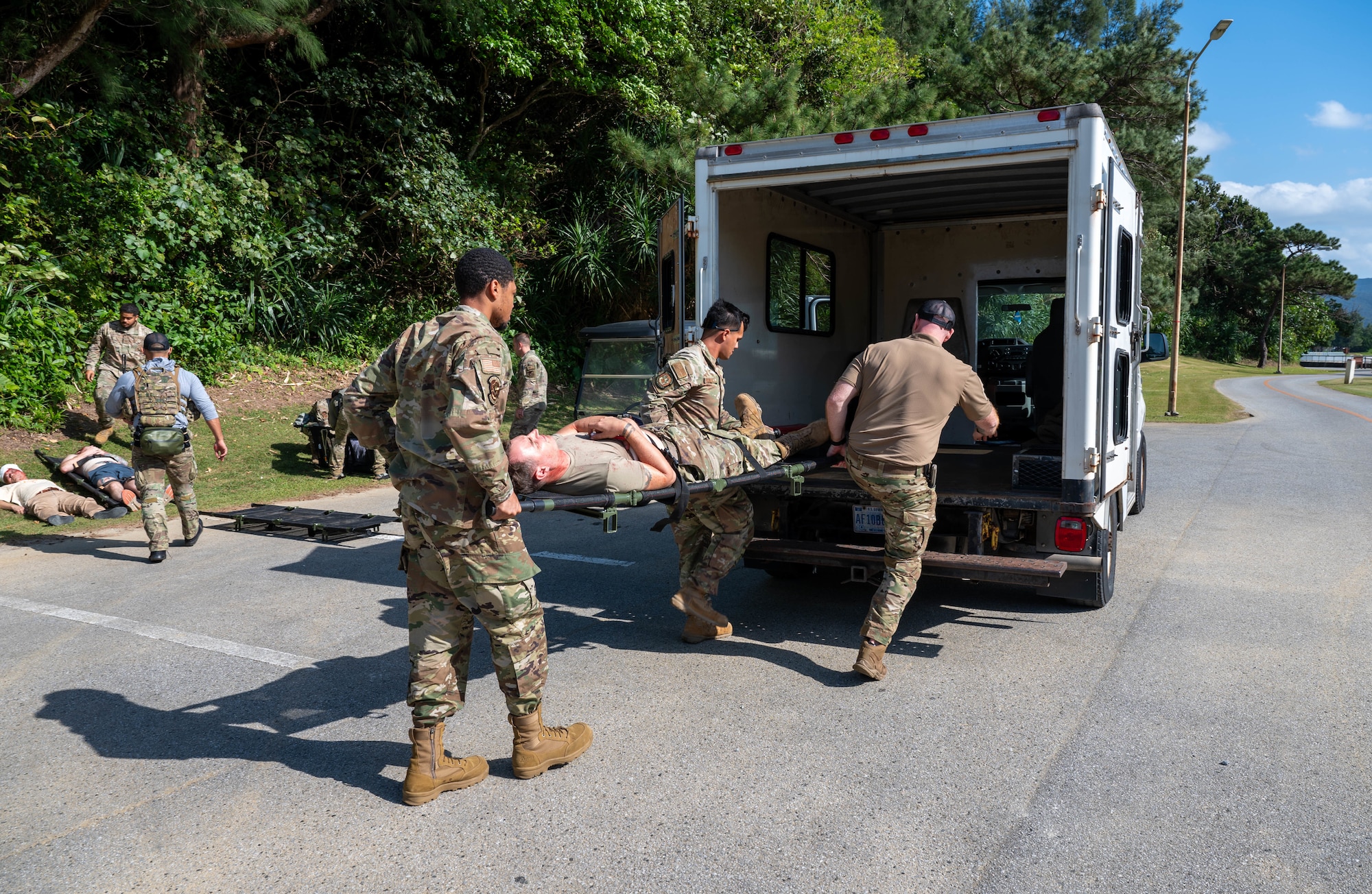 Service members carry patient into truck.