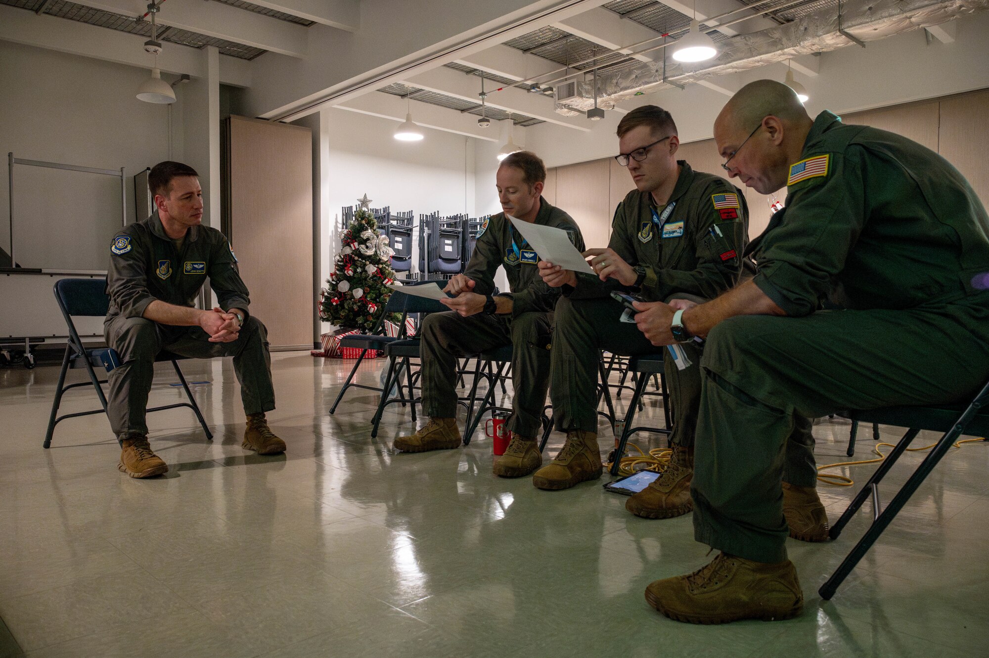Service members sit and discuss flight plan.