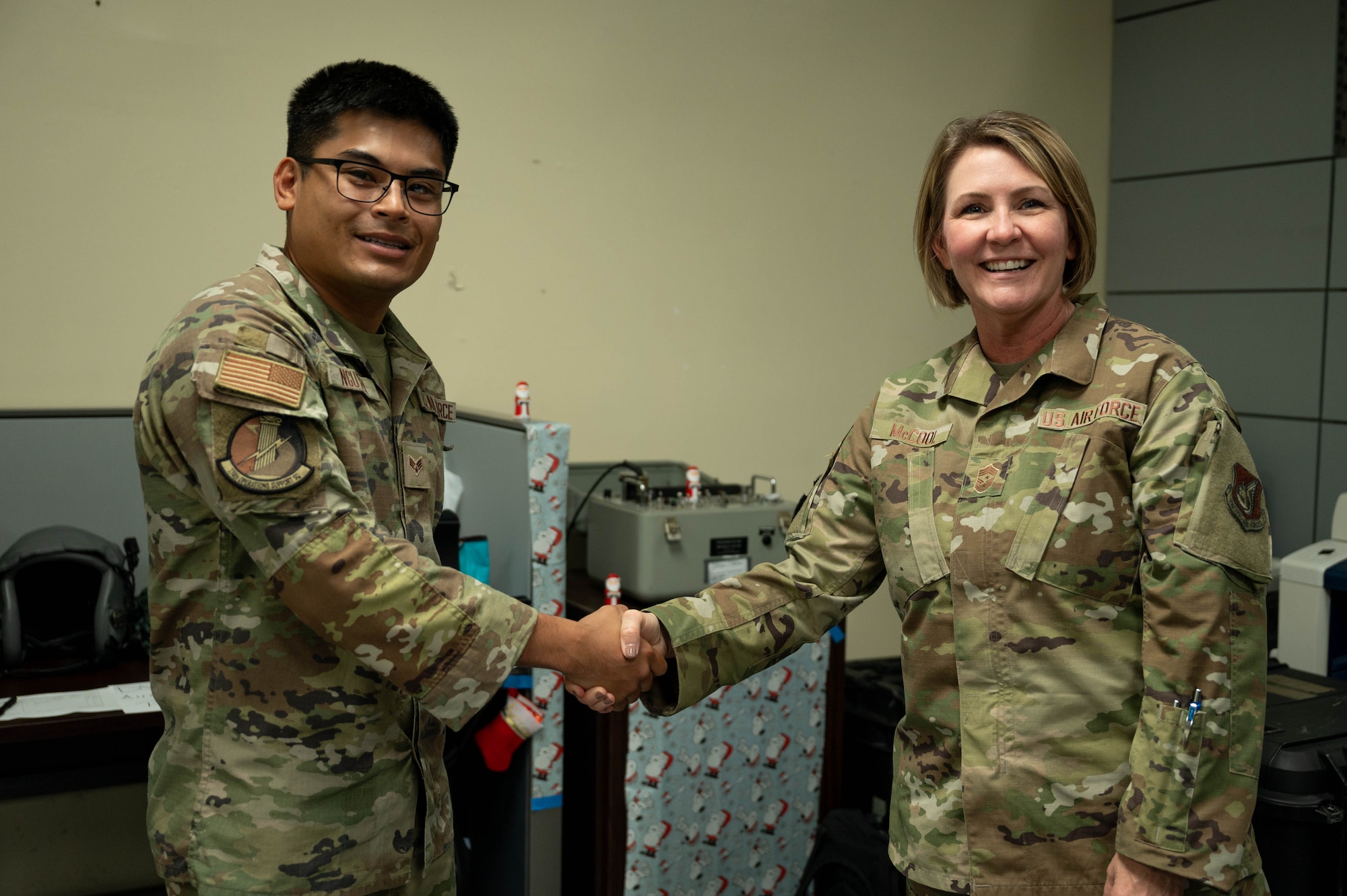 Two service members shake hands.