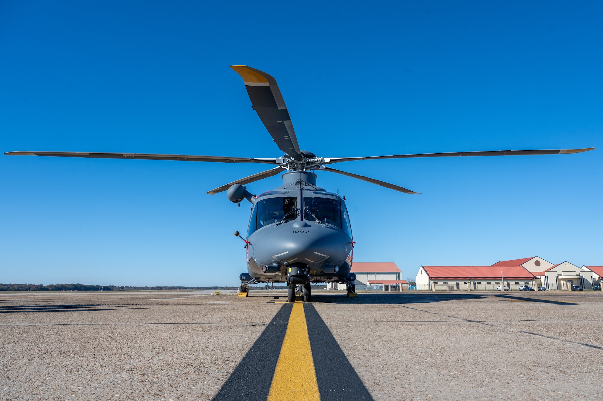 a helicopter sits on a flight line