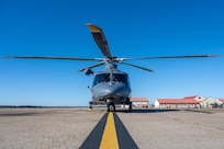 a helicopter sits on a flight line