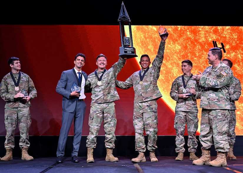 The winning team of the U.S. Space Force’s Guardian Arena hold their trophy.