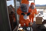 soldiers dressed in hazmat suits take liquid samples of a potential Weapon of Mass Destruction from a simulated domestic terrorist lab