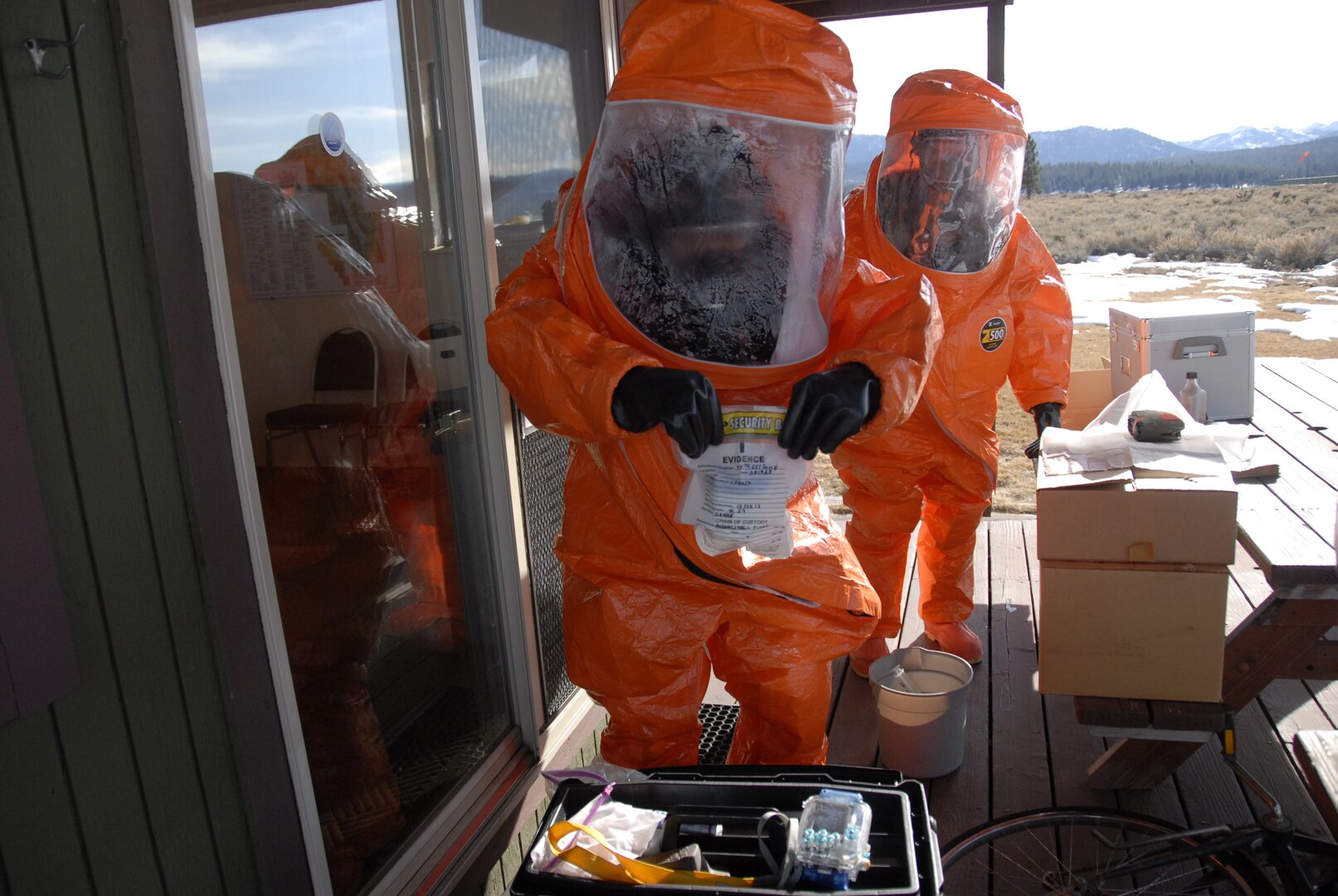 soldiers dressed in hazmat suits take liquid samples of a potential Weapon of Mass Destruction from a simulated domestic terrorist lab