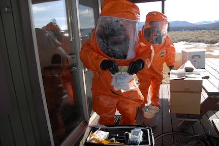 soldiers dressed in hazmat suits take liquid samples of a potential Weapon of Mass Destruction from a simulated domestic terrorist lab