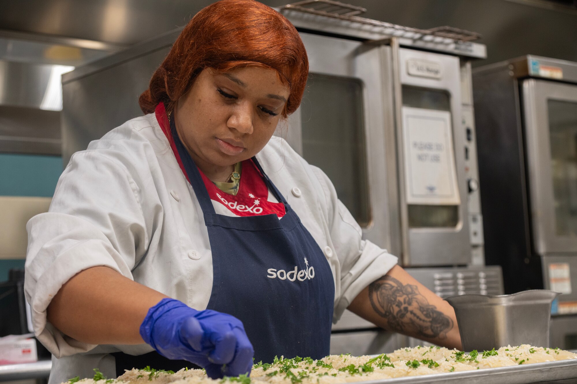 Andrea Rodrigo, 4th Force Support Squadron Cook #2, seasons bread in preparation to serve Thanksgiving meals.