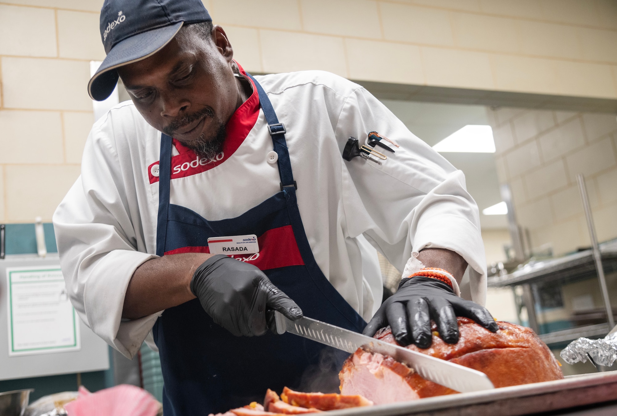 Rasada McKnight, 4th Force Support Squadron Cook #2, cuts ham in preparation to serve Thanksgiving meals.