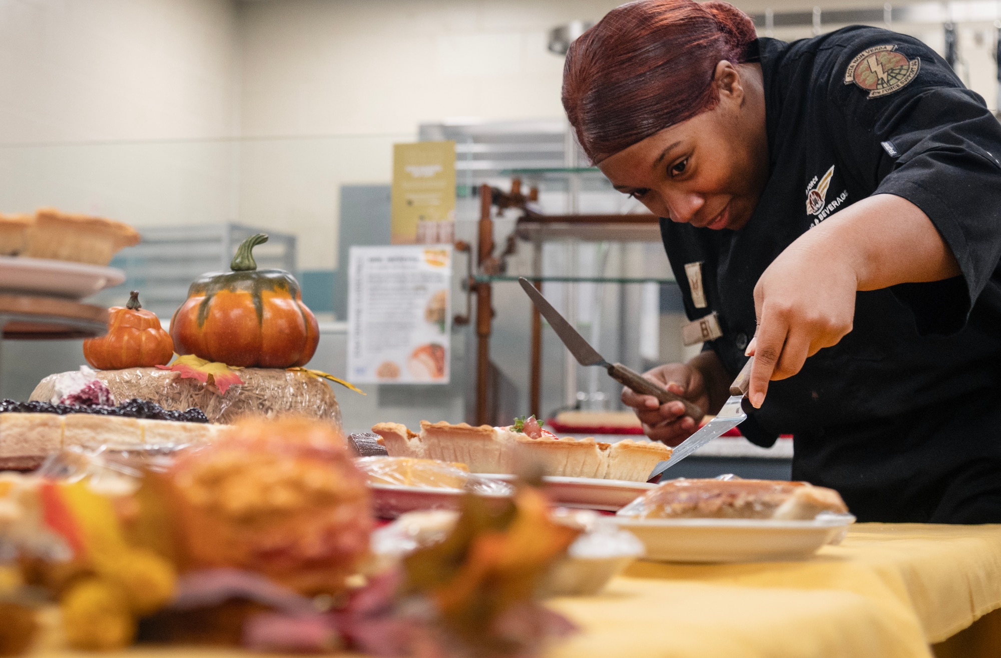 Staff Sgt. Angel Bostic, 4th Force Support Squadron food service journeyman, sets up a dessert table in preparation for a Thanksgiving meal.