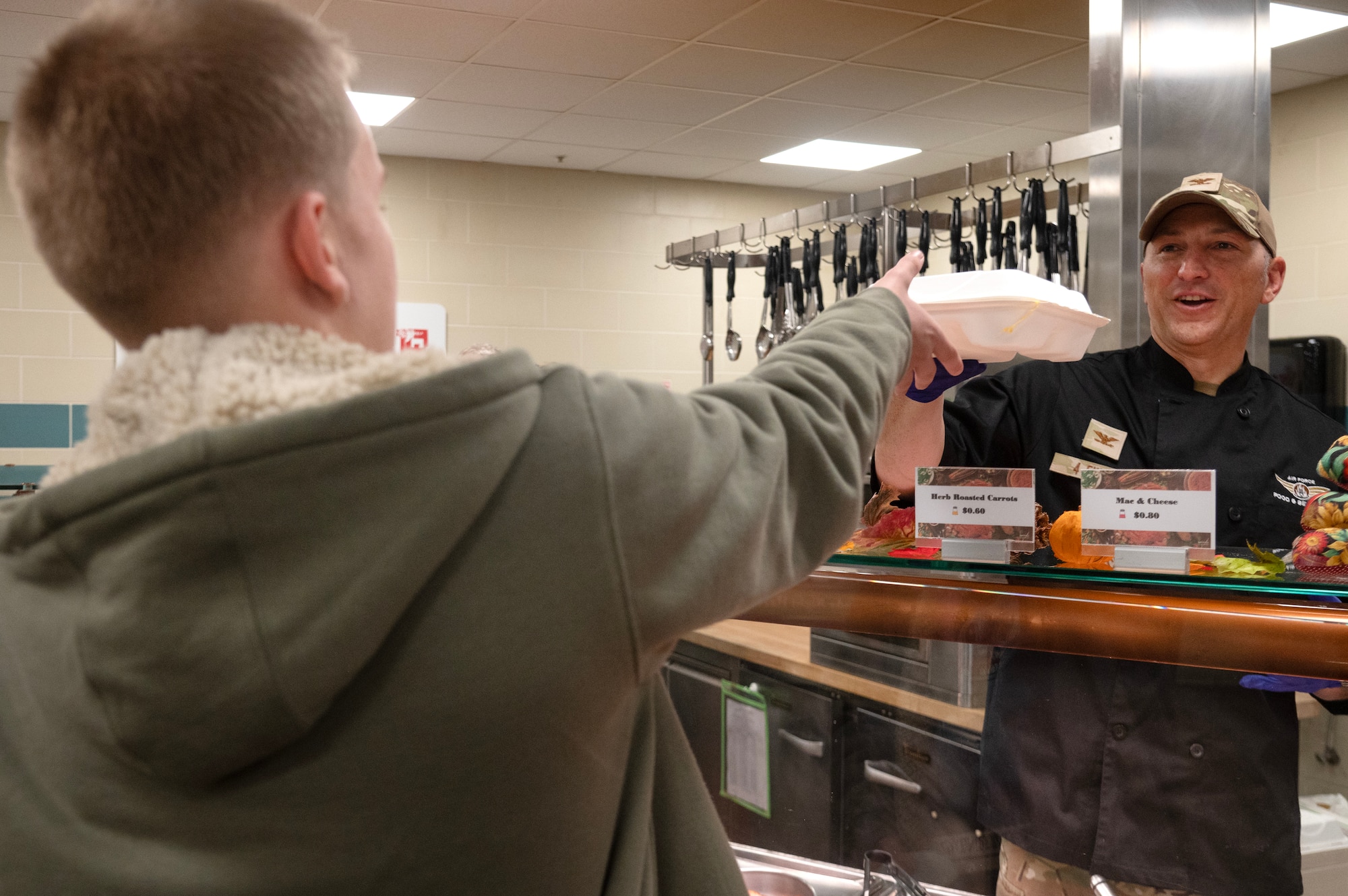 Col. Steven Bofferding, 4th Fighter Wing deputy commander, hands food to an Airman during a Thanksgiving meal.