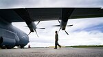 USAF Captain walks by an aircraft when conducting a post flight inspection during Operation Christmas Drop