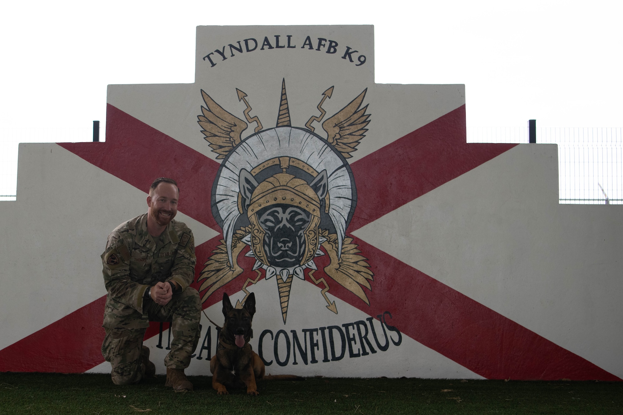 A military working dog and its trainer pose for a photo