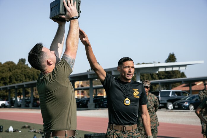 U.S. Marine Corps Training Chief, Staff Sgt. Jeffrey Gomez Jr., with Headquarters and Service Battalion, Marine Corps Recruit Depot San Diego, provides a demonstration of the proper ammunition can lift during a combat fitness test at MCRD San Diego, California, Dec. 4, 2024. The CFT is an annual fitness test that is required of all Marines to pass and maintain consisting of an 880-yard sprint, ammunition can lifts, and a maneuver under fire drill. (U.S. Marine Corps photo by Cpl. Sarah M. Grawcock)