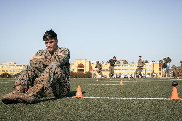 U.S. Marine Corps Combat Photographer, Lance Cpl. Jacob Hutchinson, with Headquarters and Service Battalion, Marine Corps Recruit Depot San Diego, waits for his partner during the maneuver under fire portion of a combat fitness test at MCRD San Diego, California, Dec. 4, 2024. The CFT is an annual fitness test that is required of all Marines to pass and maintain consisting of an 880-yard sprint, ammunition can lifts, and a maneuver under fire drill. (U.S. Marine Corps photo by Cpl. Sarah M. Grawcock)