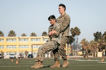 U.S. Marine Corps Combat Photographers, Lance Cpl. Jacob Hutchinson, left, and Cpl. Alexander Devereux, both with Headquarters and Service Battalion, Marine Corps Recruit Depot San Diego, conduct the maneuver under fire portion of a combat fitness test at MCRD San Diego, California, Dec. 4, 2024. The CFT is an annual fitness test that is required of all Marines to pass and maintain consisting of an 880-yard sprint, ammunition can lifts, and a maneuver under fire drill. (U.S. Marine Corps photo by Cpl. Sarah M. Grawcock)
