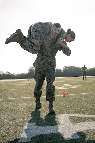 U.S. Marine Corps Deputy Staff Judge Advocate, Capt. Michael Held, center, and Finance Technician, Sgt. Jade Talone, both with Headquarters and Service Battalion, Marine Corps Recruit Depot San Diego, conduct the maneuver under fire portion of a combat fitness test at MCRD San Diego, California, Dec. 4, 2024. The CFT is an annual fitness test that is required of all Marines to pass and maintain consisting of an 880-yard sprint, ammunition can lifts, and a maneuver under fire drill. (U.S. Marine Corps photo by Cpl. Sarah M. Grawcock)