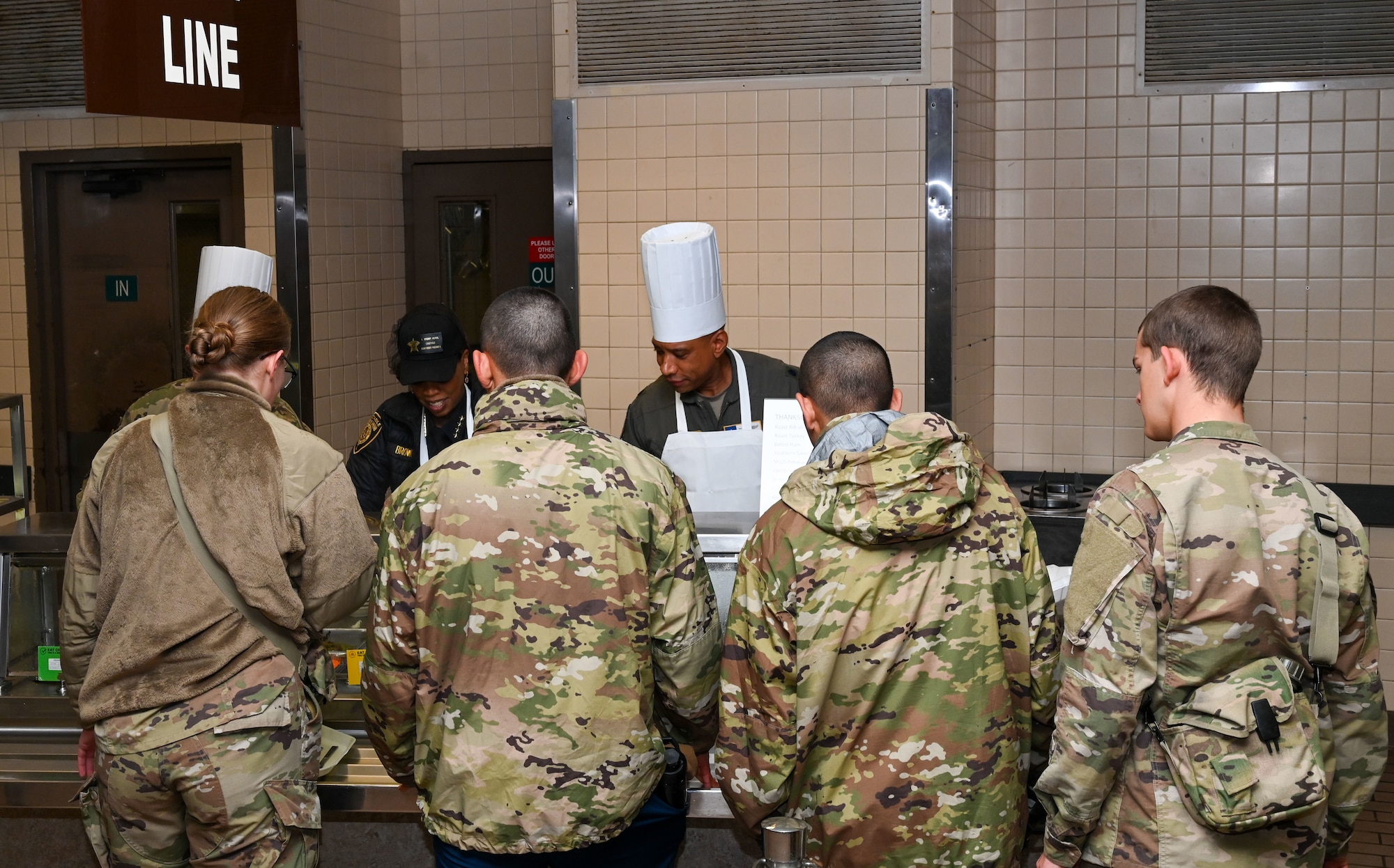 From left, Honorary Commander Constable Kathryn Brown, Bexar County 4th Precinct, and Lt. Col Jeremy Cockrell, 68th Airlift Squadron commander, prepare plates of food for service members during the “Feed the Troops” event at the Live Oak Dining Facility on Joint Base San Antonio-Lackland, Texas, Dec. 7, 2024.