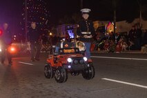 U.S. Marine Corps Cpl. Sarah Grawcock, the mascot handler and photo chief for Marine Corps Recruit Depot San Diego, and Lance Cpl. Bruno, the MCRD San Diego and the Western Recruiting Region mascot, march in the Coronado Holiday Parade in Coronado, Dec. 6, 2024. The mascot’s job is to boost morale, participate in outreach work and attend events and ceremonies. (U.S. Marine Corps photo by Cpl. Alexandra M. Earl)