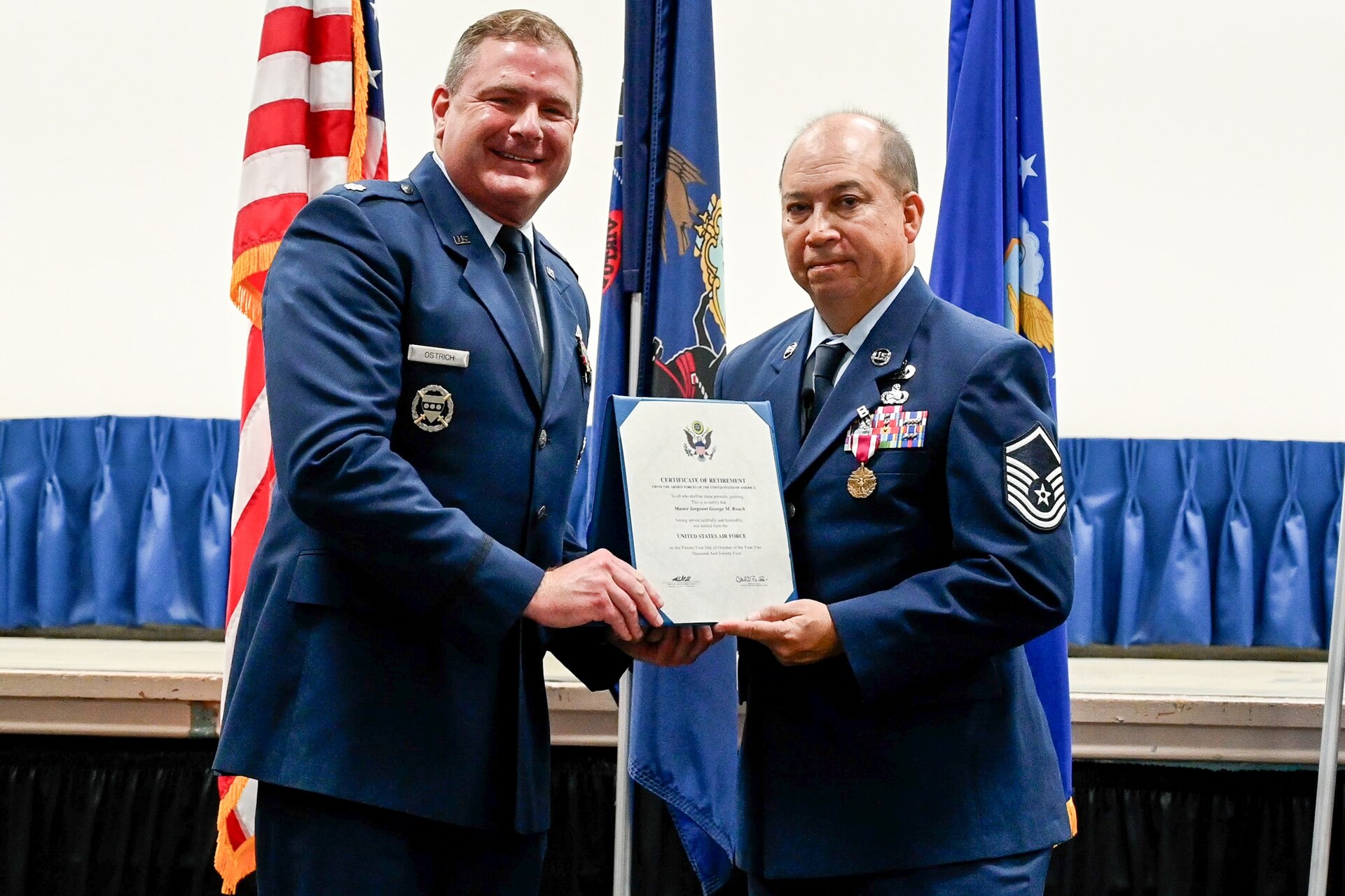 Pennyslvania Air National Guardsmen Lt. Col. Jay Ostrich, left, and Master Sgt. George Roach, display a certificate of retirement during Roach's retirement ceremony at Biddle ANG Base Horsham, Pennsylvania, December 7, 2024. Master Sgt. George Roach, 111th Attack Wing Public Affairs Senior Enlisted Leader retired after career of serving for more than 37 years. (U.S. Air National Guard photo by Airman 1st Class Matthew Bergh)