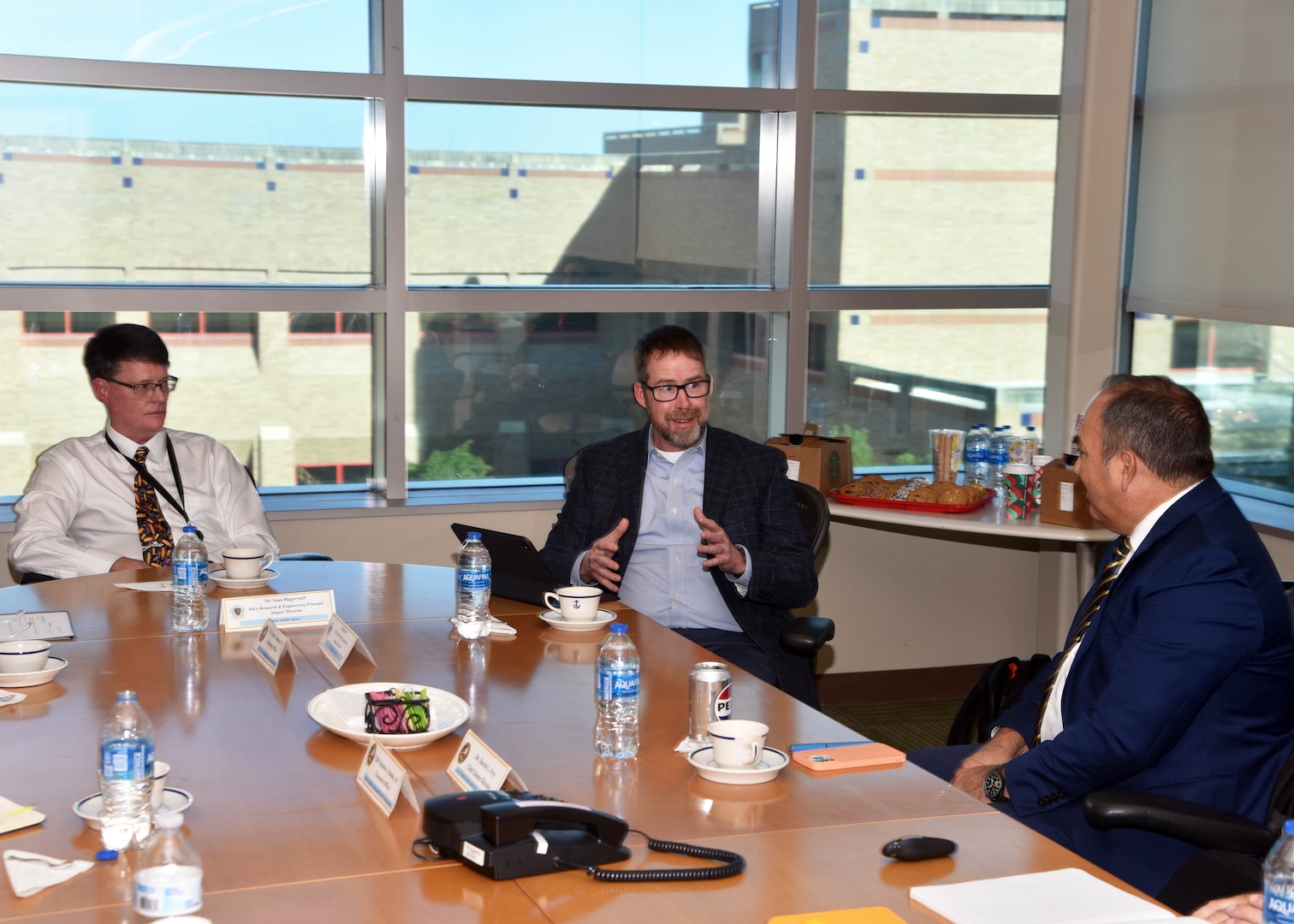 JOINT BASE SAN ANTONO-FORT SAM HOUSTON - (Dec. 10, 2024) - Deputy Director Matt Gray, Research and Engineering Directorate, Defense Health Agency (DHA), joined by Principal Deputy Director Dr. Sean Biggerstaff, speaks with leadership and staff of Naval Medical Research Unit (NAMRU) San Antonio about investment strategies and portfolio management  at the Battlefield Health and Trauma Research Institute to discussed prioritization of research priorities and the importance of building relationships in reference to funding of core capabilities and fiscal responsibilities. NAMRU San Antonio's mission is to conduct gap driven combat casualty care, craniofacial, and directed energy research to improve survival, operational readiness, and safety of Department of Defense (DoD) personnel engaged in routine and expeditionary operations. It is one of the leading research and development laboratories for the U.S. Navy under the DoD and is one of eight subordinate research commands in the global network of laboratories operating under the Naval Medical Research Command in Silver Spring, Md. (U.S. Navy photo by Burrell Parmer, NAMRU San Antonio Public Affairs/Released)