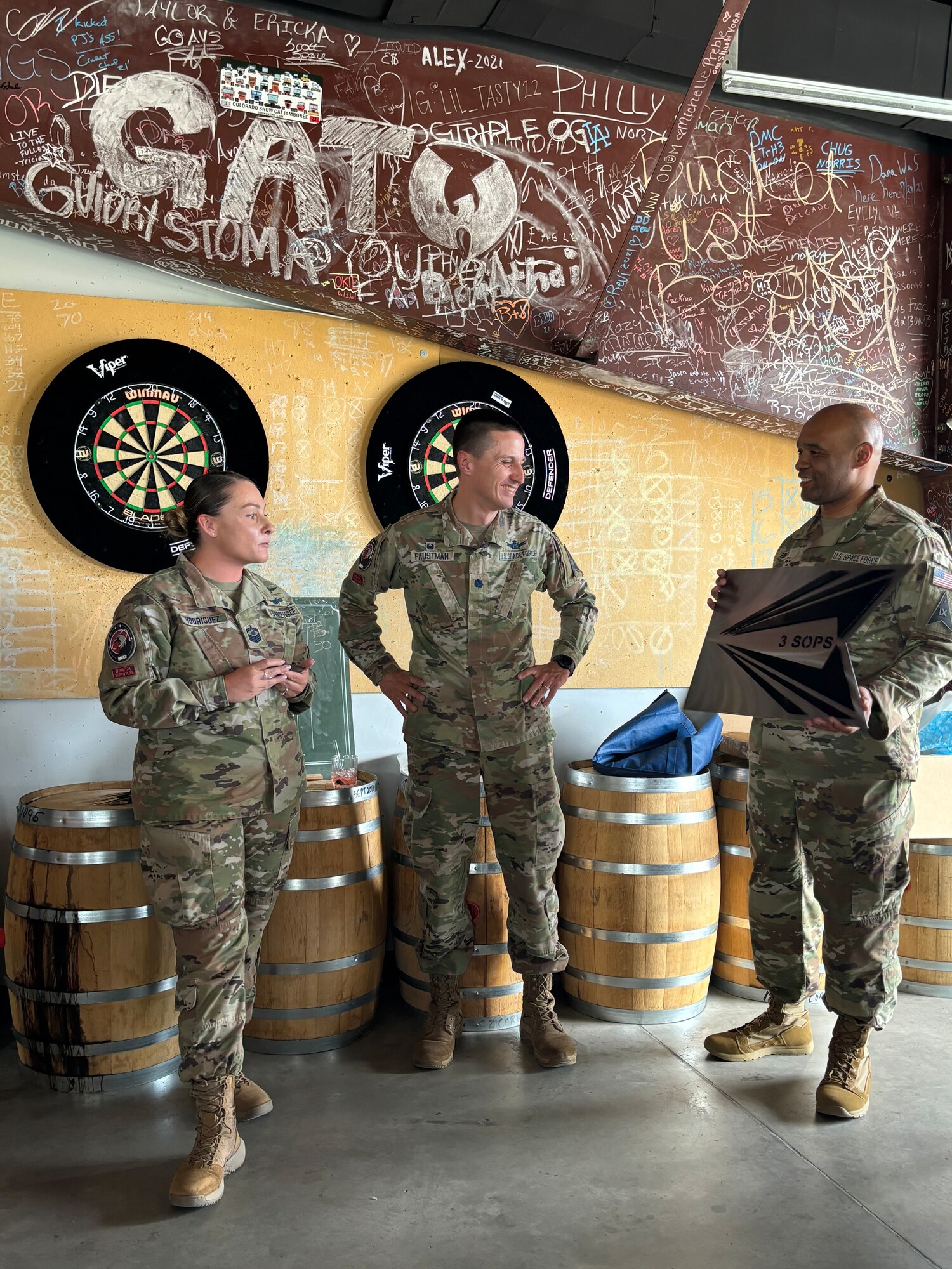 Uniformed member presents another military member with an award.