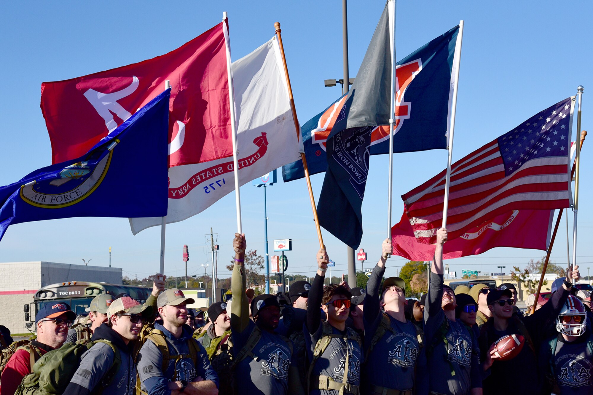 People walk together and some are carrying flags.