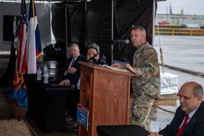 Man in army uniform stand behind a podium while speaking