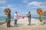 Two leaders cutting a ribbon on a pier in the Philippines
