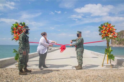 Two leaders cutting a ribbon on a pier in the Philippines