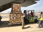 US Soldiers use forklift to load a pallet onto a cargo plane.