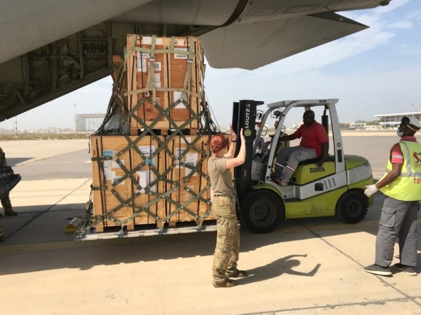 US Soldiers use forklift to load a pallet onto a cargo plane.