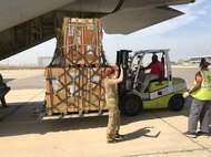 US Soldiers use forklift to load a pallet onto a cargo plane.