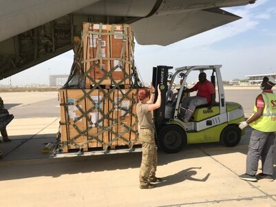 US Soldiers use forklift to load a pallet onto a cargo plane.