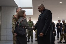 Secretary of Defense Lloyd J. Austin III greets Katherine Monahan, deputy chief of mission to Japan, alongside military from the United States, Japan, and Australia during his visit to the Ground Component Command Building at Camp Asaka, Japan, Dec. 11, 2024.