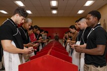 U.S. Marine Corps recruits with India Company, 3rd Recruit Training Battalion, make their scripted phone call home during a receiving event at Marine Corps Recruit Depot San Diego, California, Dec. 2, 2024. During the receiving process, recruits are taken to the United Service Organizations for accountability, checked for contraband, given haircuts, make a scripted phone call home, and issued gear required for training. (U.S. Marine Corps photo by Lance Cpl. Janell B. Alvarez)