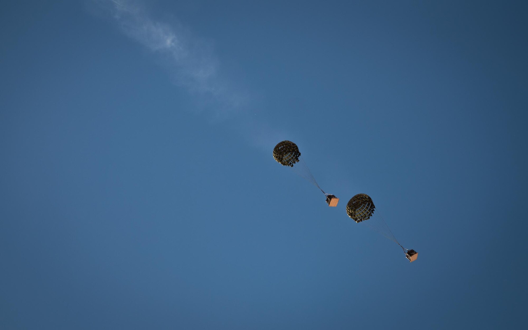 Cargo drops descend under parachutes from a U.S. Marine Corps KC-130J Hercules during Exercise Desert Hammer 25-1 at Auxiliary Airfield 6 near Gila Bend, Ariz., Nov. 15, 2024. The exercise integrates Agile Combat Support and Large Force Exercise capabilities in a contested environment. (U.S. Air Force photo by Senior Airman Jacob Dastas)
