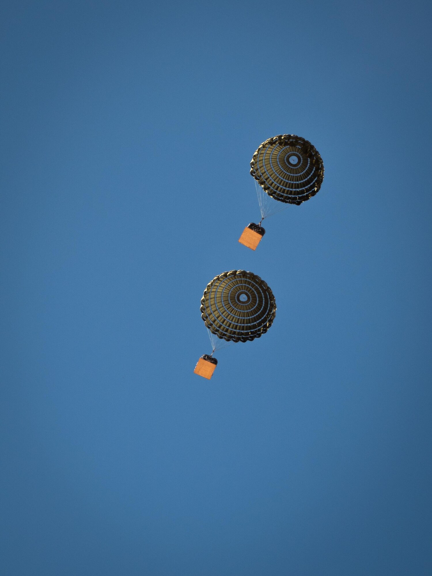 Cargo drops descend under parachutes from a U.S. Marine Corps KC-130J Hercules during Exercise Desert Hammer 25-1 at Auxiliary Airfield 6 near Gila Bend, Ariz., Nov. 15, 2024. The exercise integrates Agile Combat Support and Large Force Exercise capabilities in a contested environment. (U.S. Air Force photo by Senior Airman Jacob Dastas)